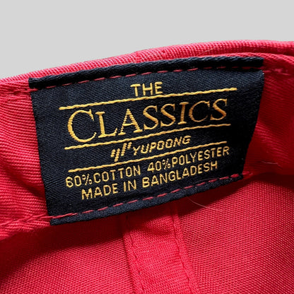 Raree Finds Yupoong The Classics interior label on a red snapback hat showing material composition and origin