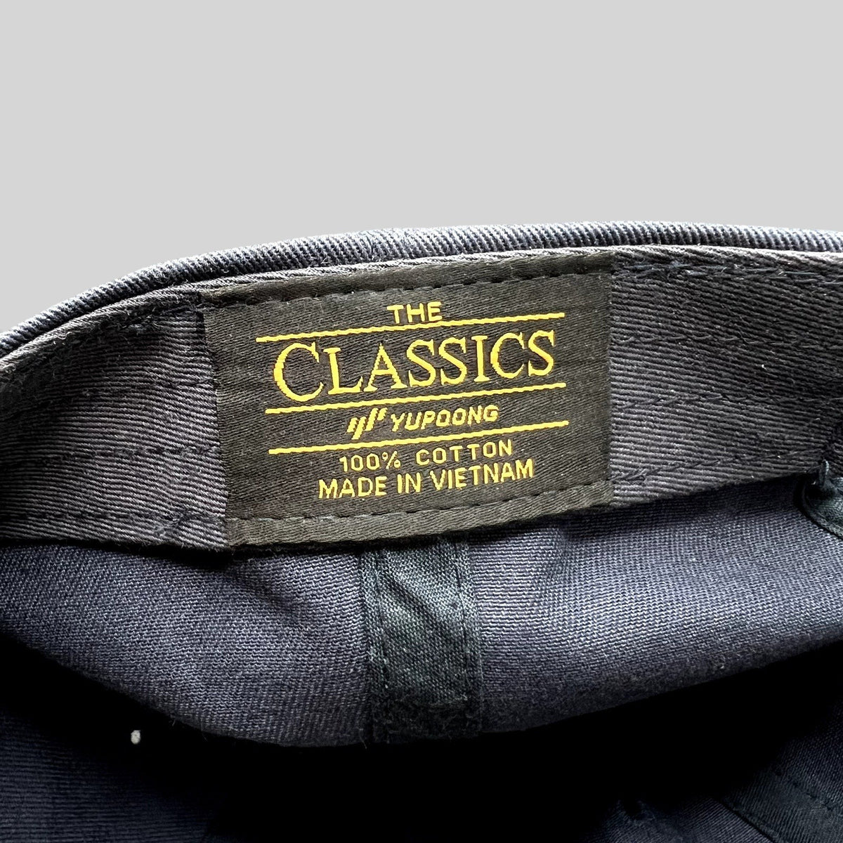 Raree Finds navy blue cotton dad cap interior featuring a Yupoong Classics brand label with gold embroidery