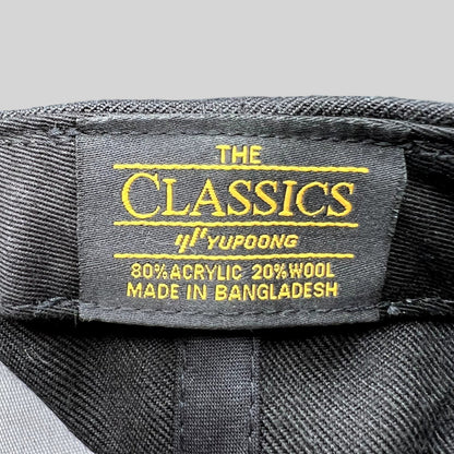 Raree Finds black Yupoong The Classics snapback hat interior label showing material composition and origin