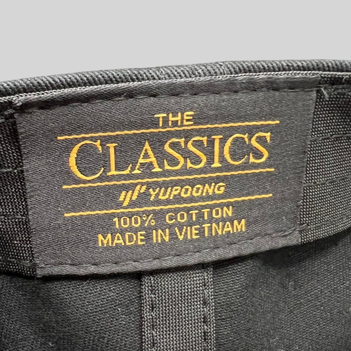 Raree Finds Yupoong The Classics black cotton hat interior label with gold embroidery