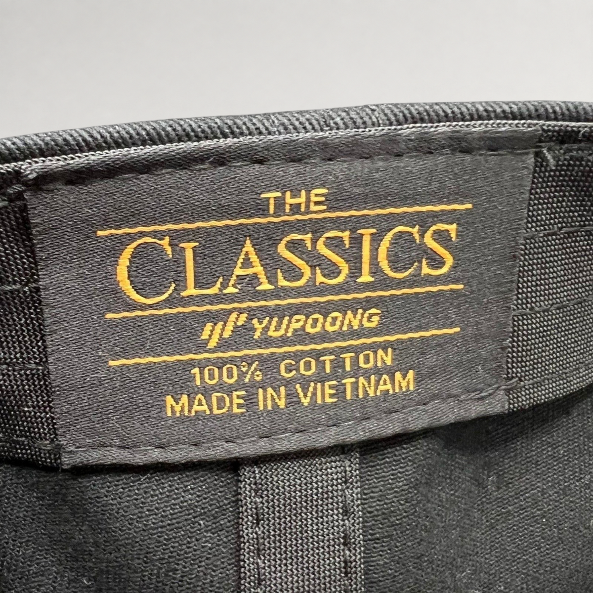 Raree Finds Yupoong The Classics black cotton hat interior label with gold embroidery