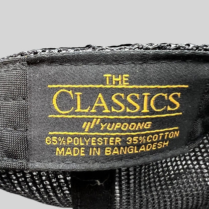 Raree Finds black Yupoong Classics trucker hat interior label showing material composition and origin