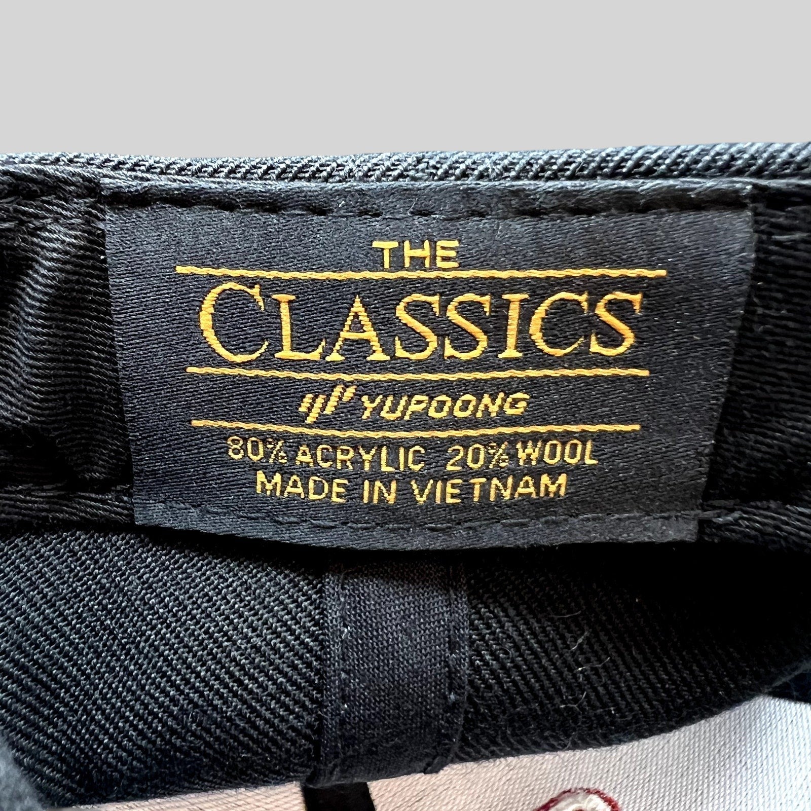 Raree Finds Yupoong Classics black snapback hat interior label showing material composition and brand branding