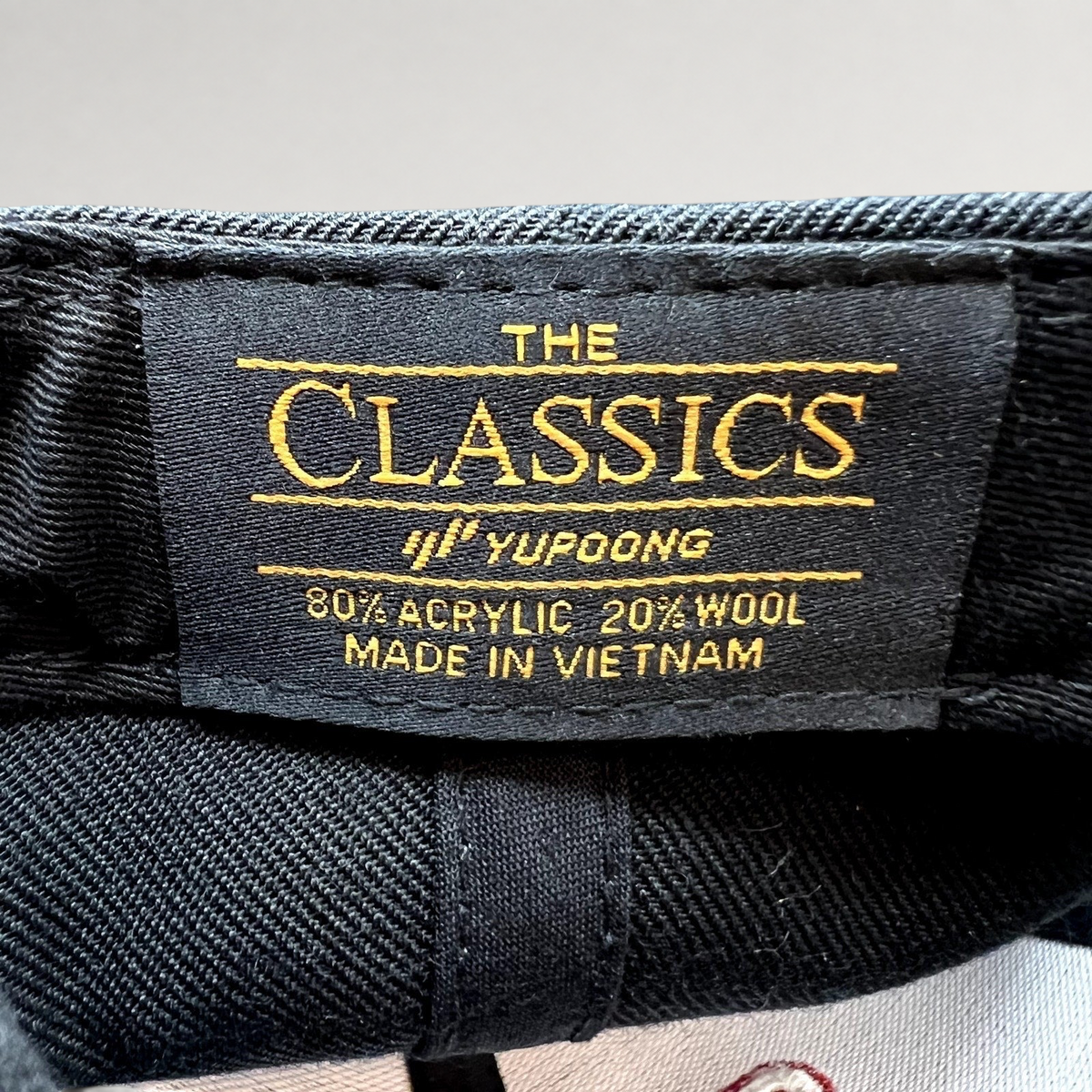 Raree Finds Yupoong Classics black snapback hat interior label showing material composition and brand branding