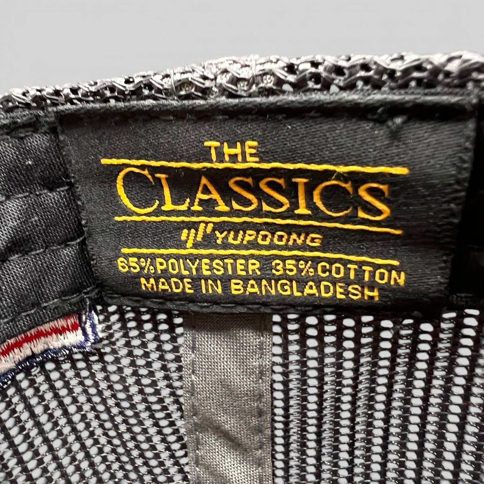 Raree Finds Yupoong Classics interior hat label showing material composition and brand logo on black fabric