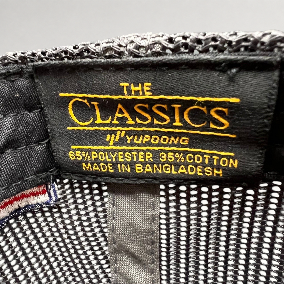 Raree Finds Yupoong Classics interior hat label showing material composition and brand logo on black fabric