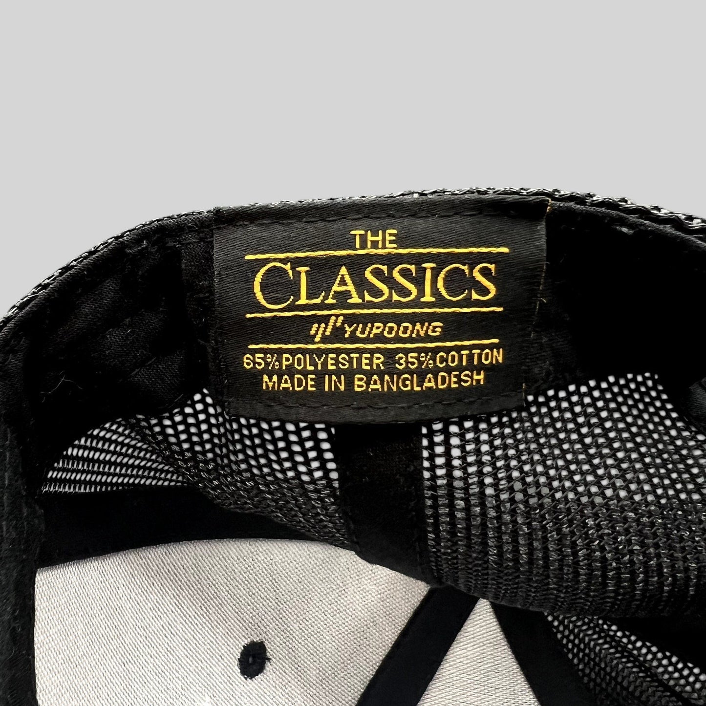 Raree Finds Yupoong Classics trucker hat interior label showing material composition and branding
