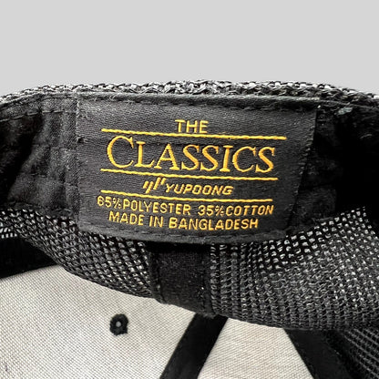 Raree Finds black Yupoong Classics trucker hat interior tag showing material composition and manufacturing origin