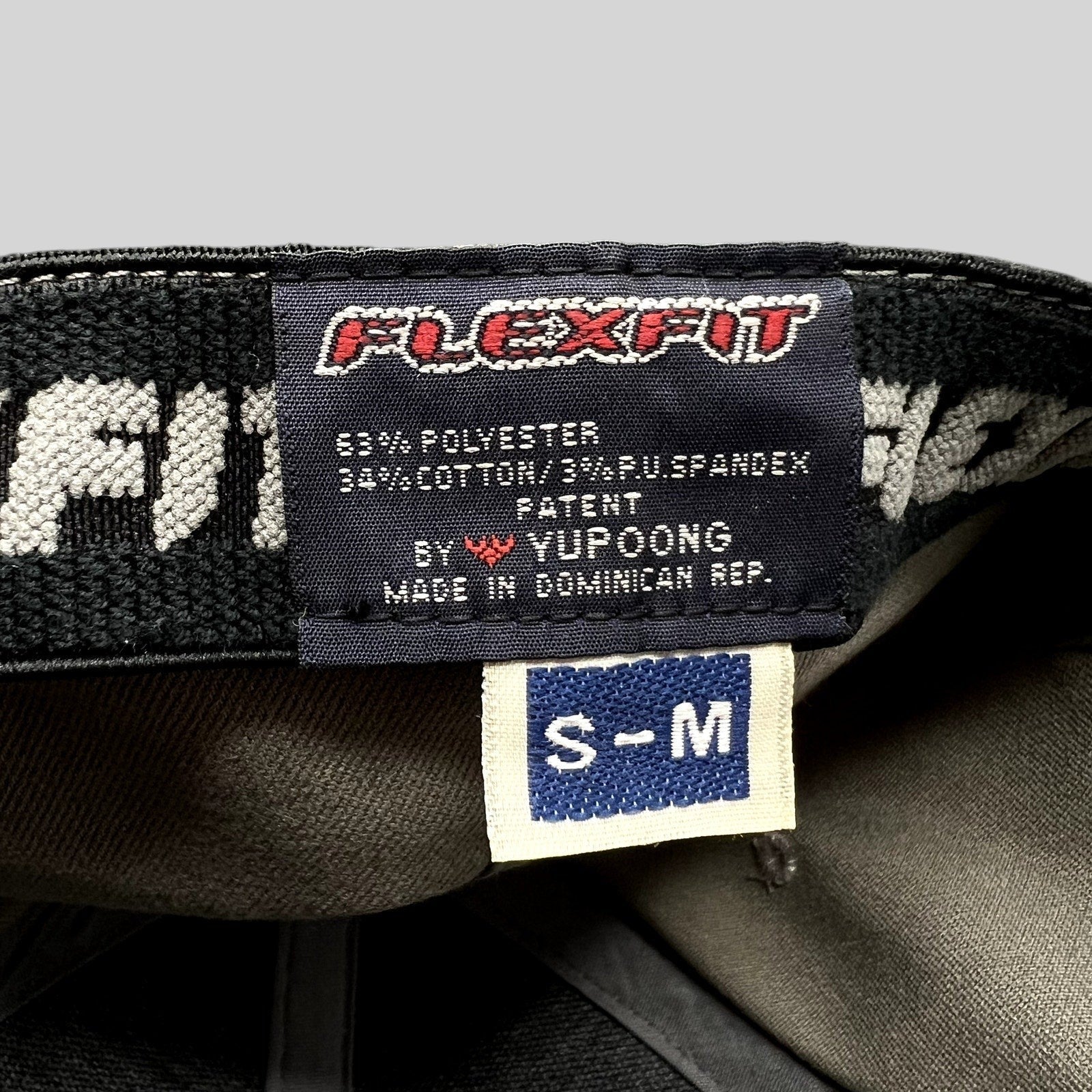 Raree Finds Yupoong Flexfit hat interior label showing size S/M and material composition in gray baseball cap