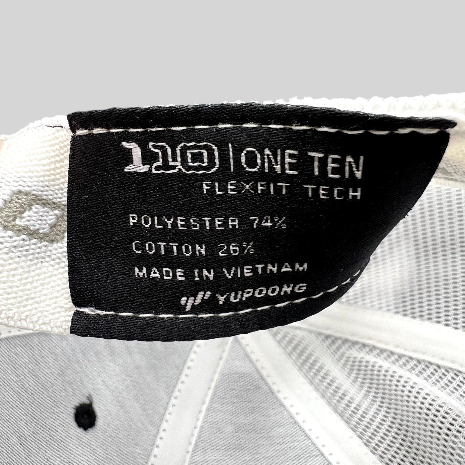Raree Finds Yupoong Flexfit 110 trucker hat interior label showing polyester and cotton material composition