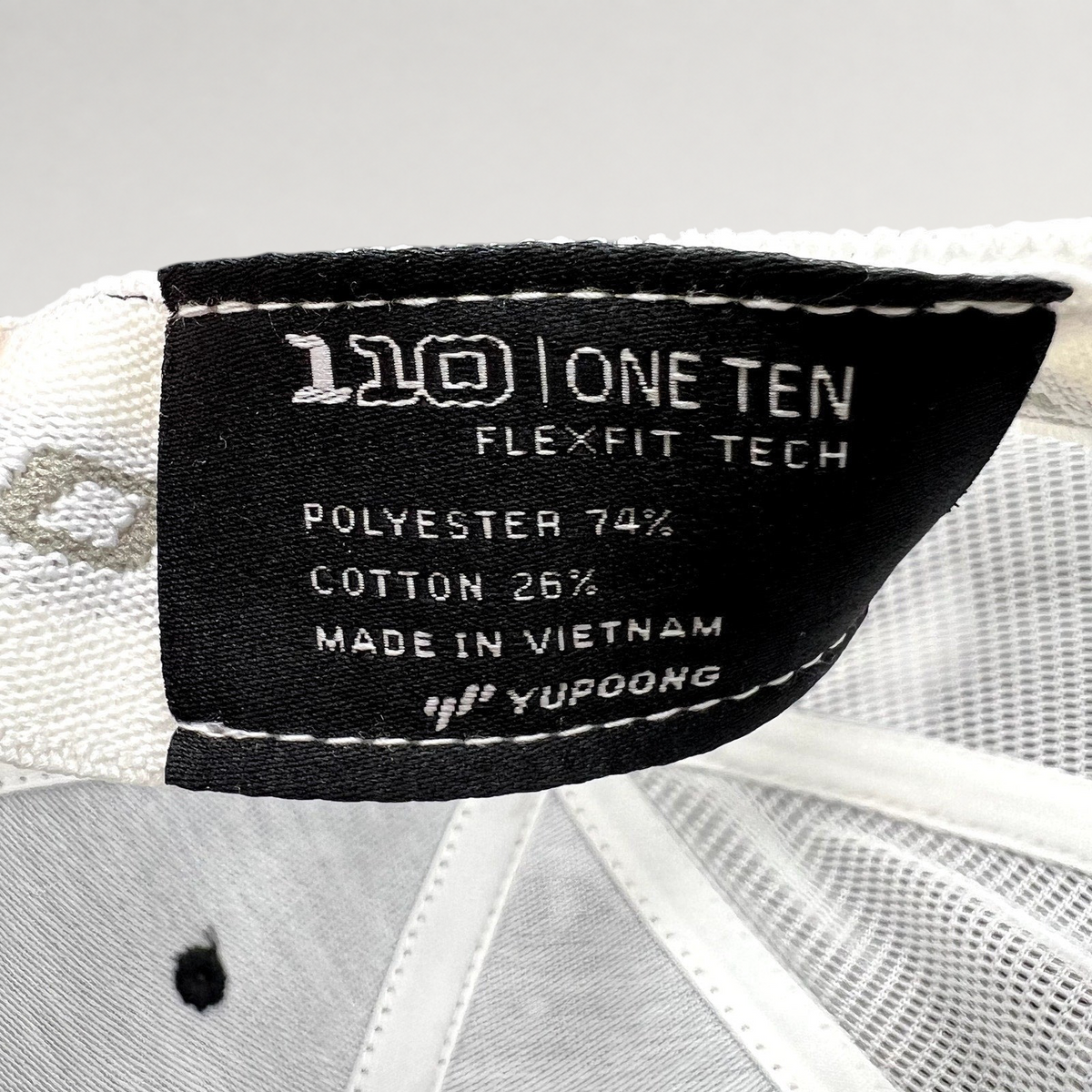 Raree Finds Yupoong Flexfit 110 trucker hat interior label showing polyester and cotton material composition