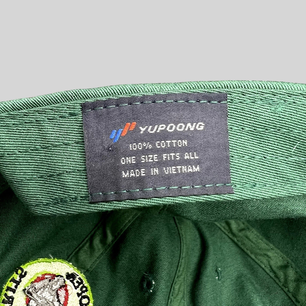 Raree Finds forest green Yupoong cotton strapback hat interior label showing brand and manufacturing details