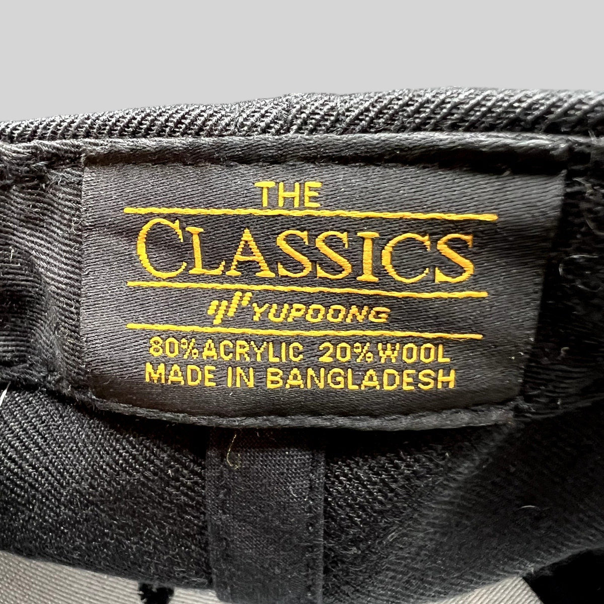 Raree Finds snapback hat interior label showing The Classics Yupoong branding and material composition