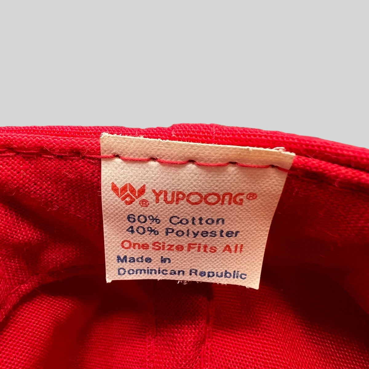 Raree Finds vintage Yupoong hat interior tag showing 60 percent cotton and 40 percent polyester fabric composition