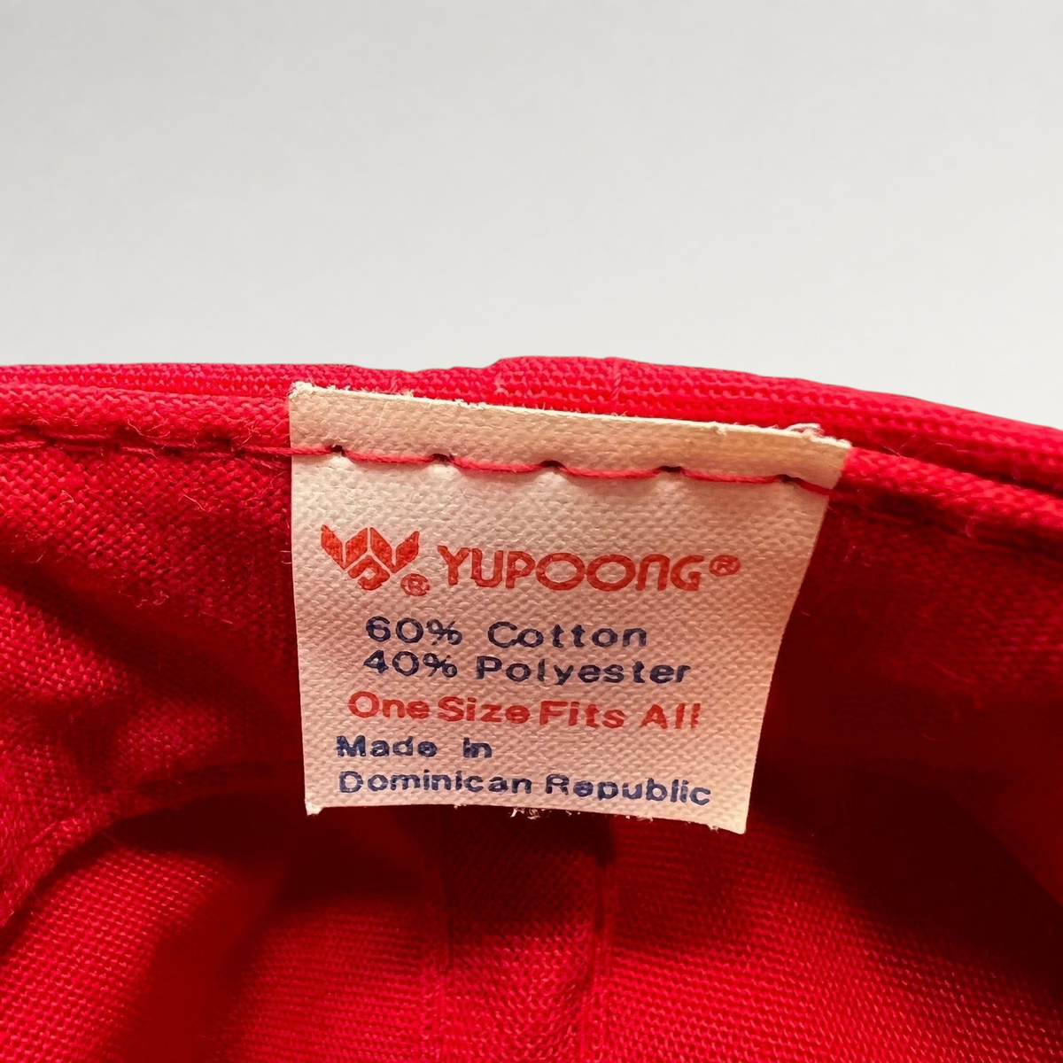 Raree Finds vintage Yupoong hat interior tag showing 60 percent cotton and 40 percent polyester fabric composition