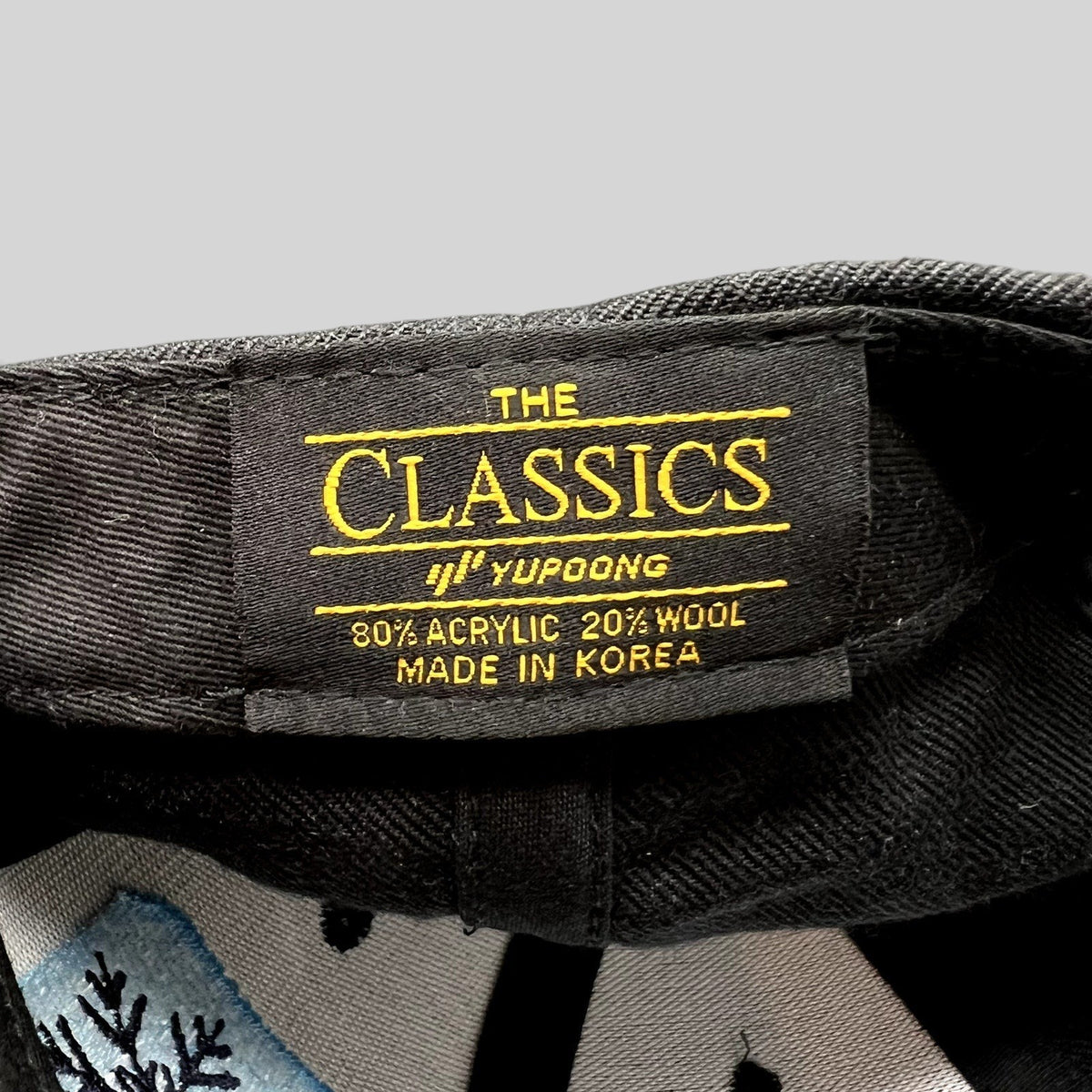Raree Finds vintage Yupoong The Classics snapback hat interior tag showing material blend and made in Korea label