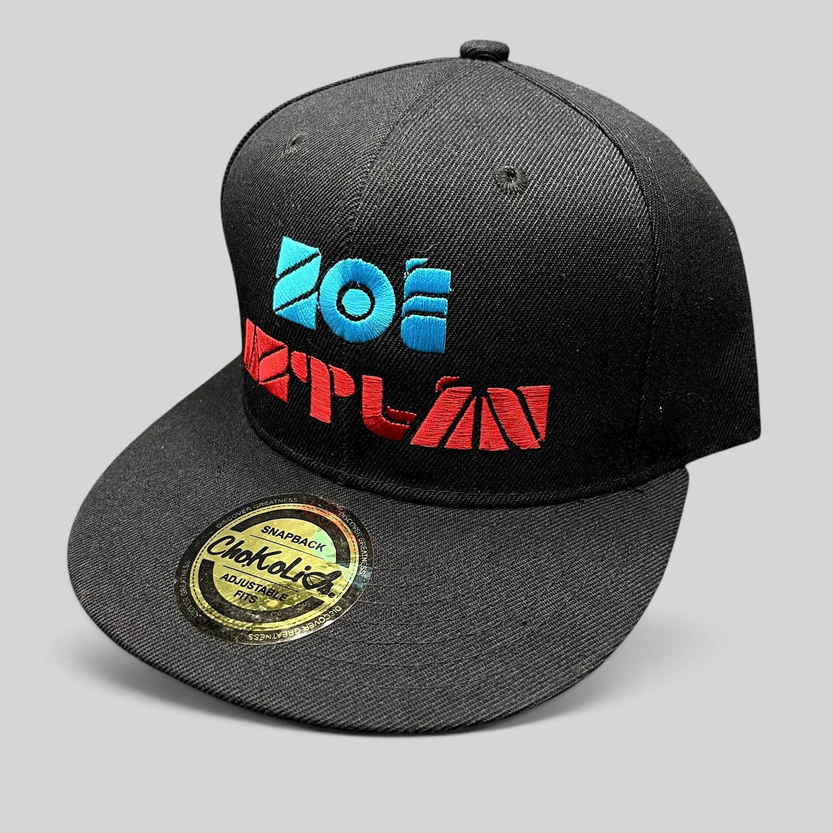 Raree Finds black Chokolids snapback hat featuring embroidered turquoise and red Zoe Aztlan album graphics on front
