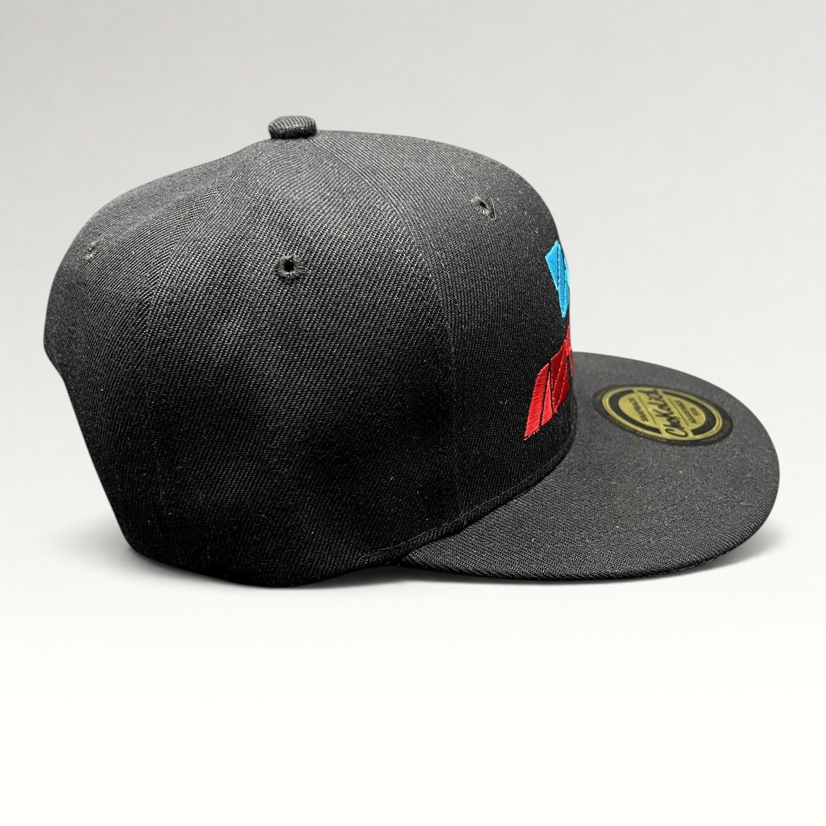 Raree Finds black Chokolids snapback hat featuring embroidered Zoe Aztlan album graphics in turquoise and red